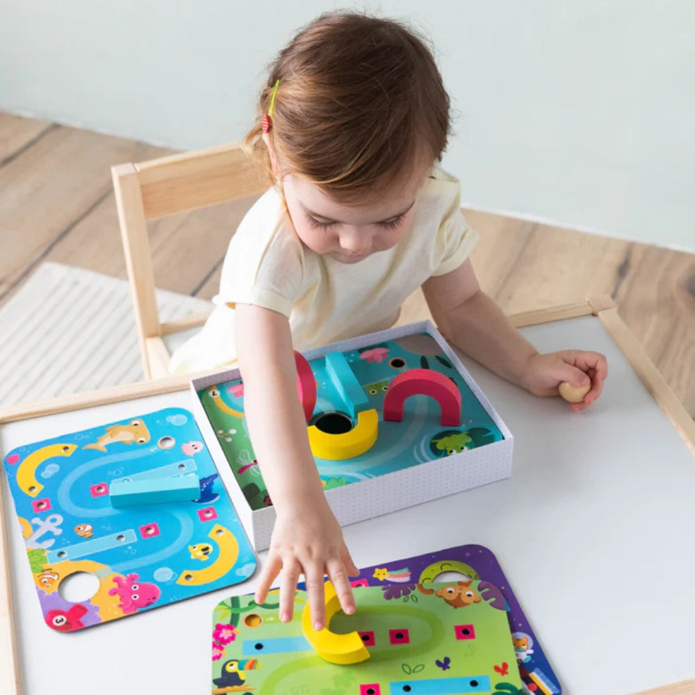 Juego de destreza Funny Ball de Goula para niños desde 3 años. Incluye 4 placas con circuitos y piezas de madera para guiar una bolita, ideal para desarrollar coordinación y pensamiento lógico.