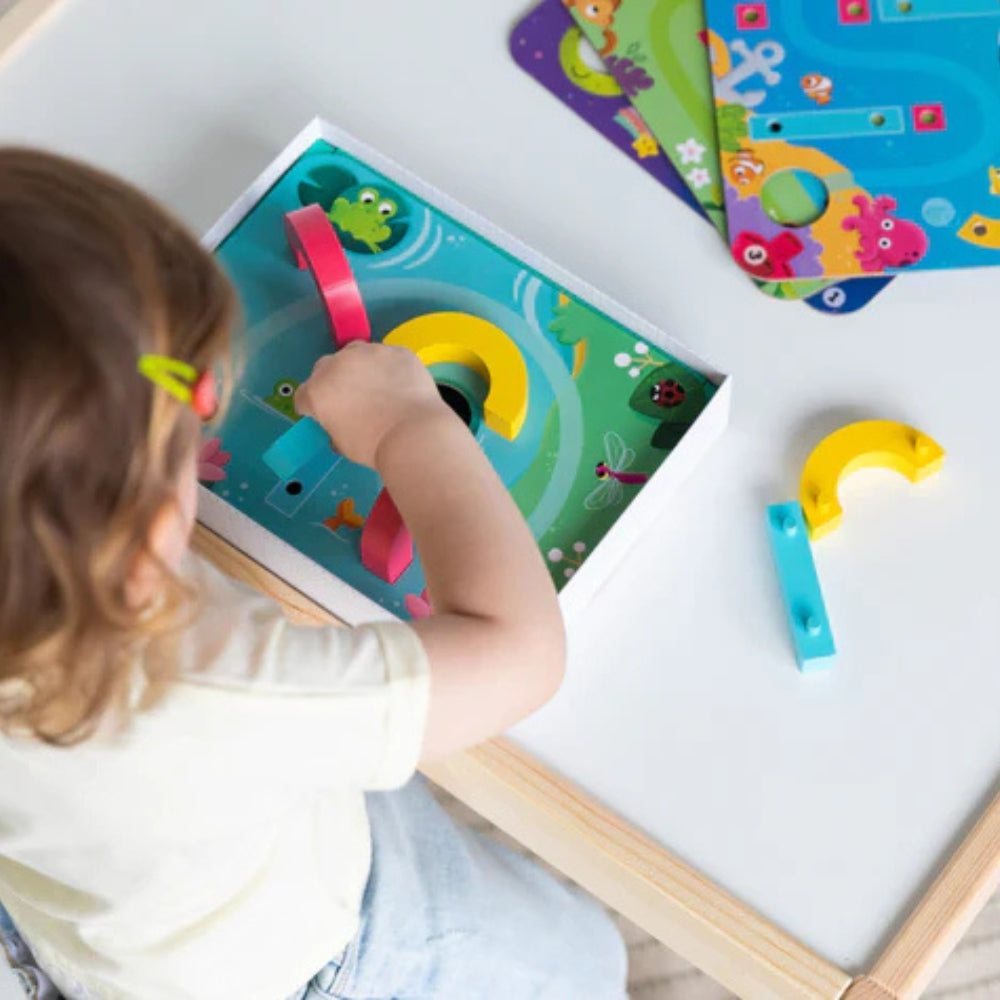 Juego de destreza Funny Ball de Goula para niños desde 3 años. Incluye 4 placas con circuitos y piezas de madera para guiar una bolita, ideal para desarrollar coordinación y pensamiento lógico.