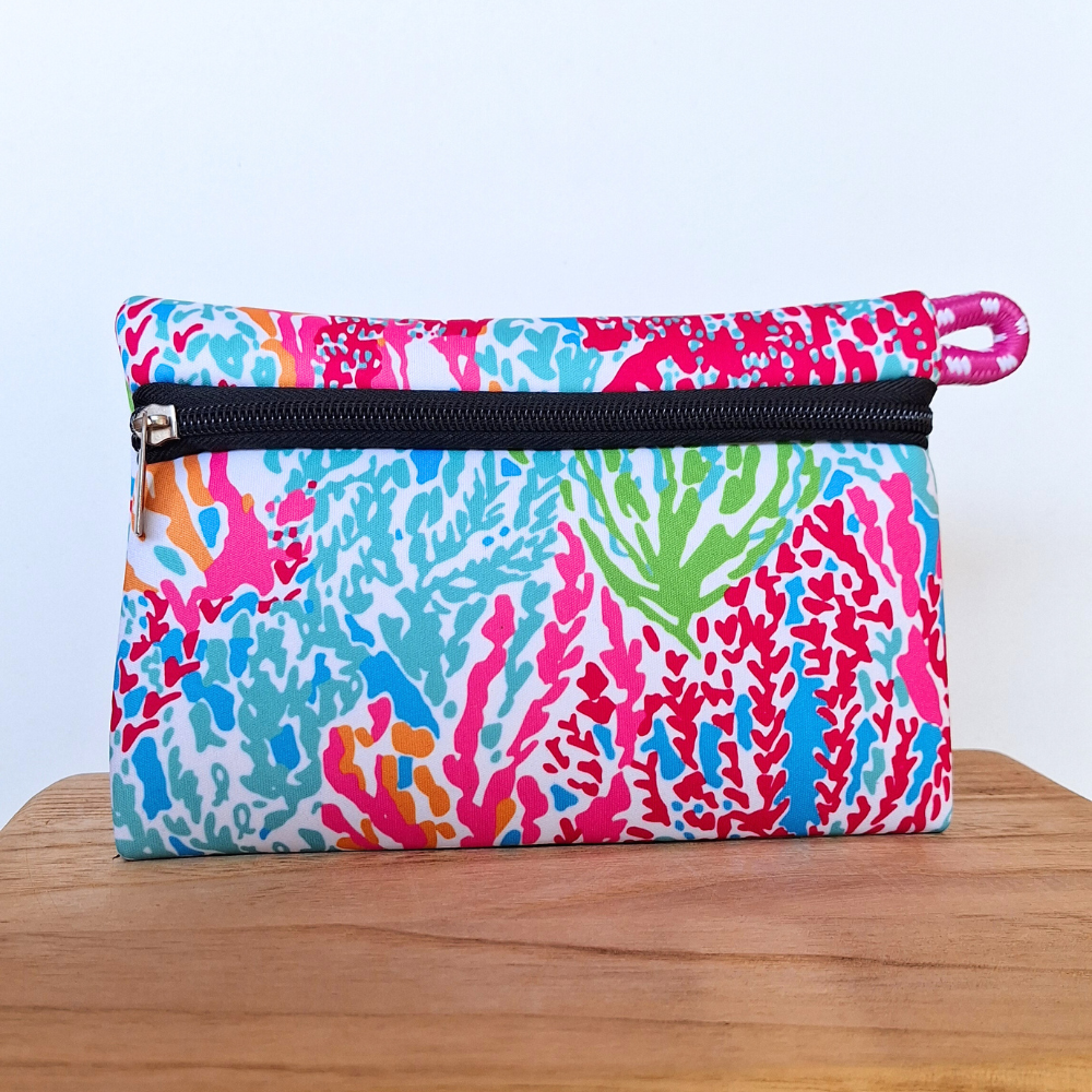 Estuche de neopreno con diseño de corales, ideal para cosméticos, accesorios y uso diario. Perfecto para universidad, trabajo, gimnasio o playa.