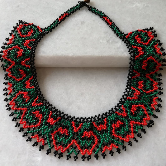Collar de cuentas hecho a mano en tonos verde y coral, artesanía peruana, diseño colorido y elegante.