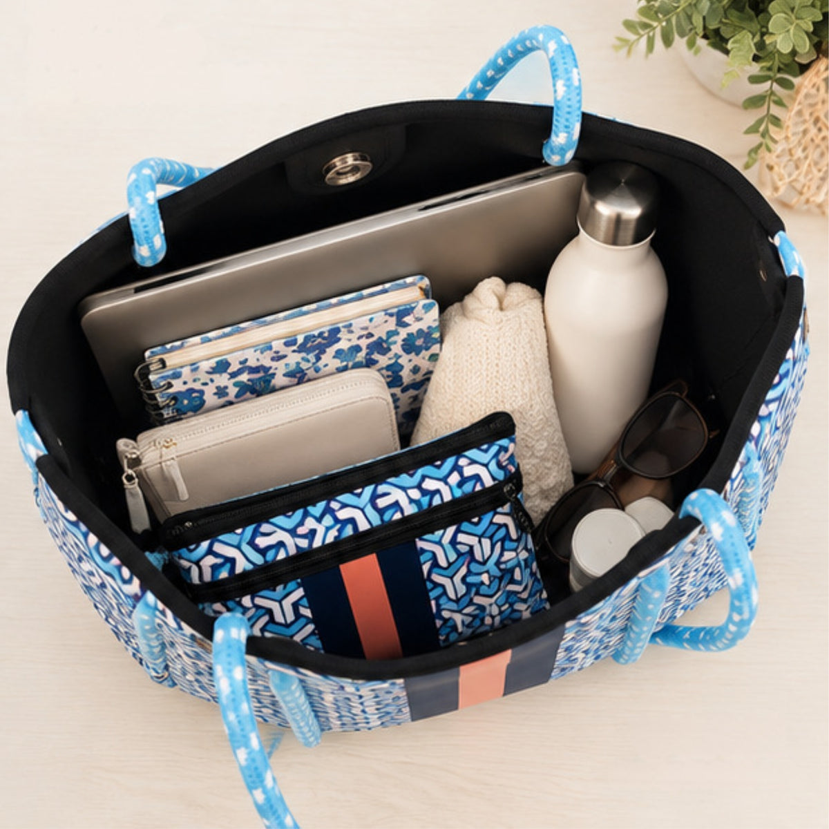 Bolso de neopreno azul con diseño geométrico y neceser incluido.