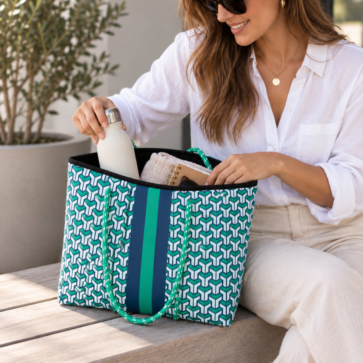 Bolso de neopreno azul con verde en uso, con interior amplio y artículos personales.