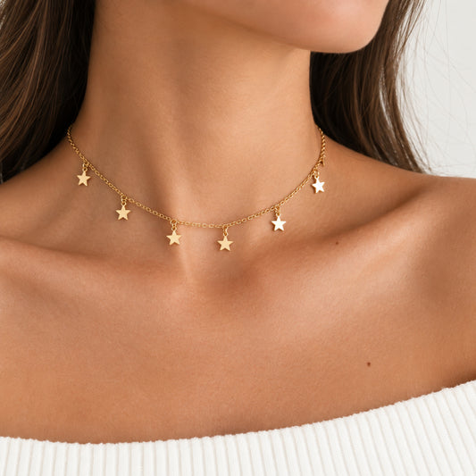Choker de estrellas dorado con cadena y dijes de estrellas.
