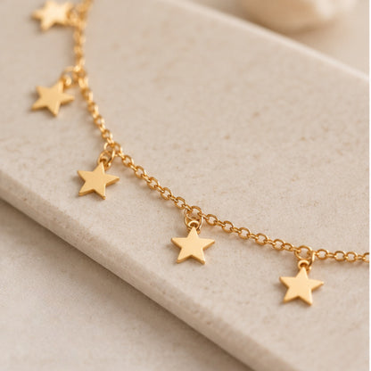 Choker de estrellas dorado con cadena y dijes de estrellas.