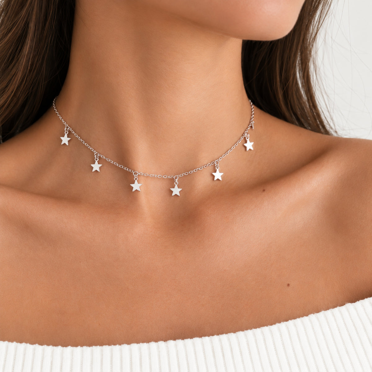 Choker de estrellas plateado con cadena y dijes de estrellas.