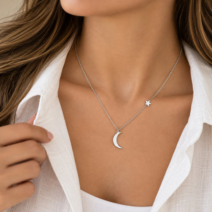 Collar de luna y estrella plateado usado con blusa blanca.