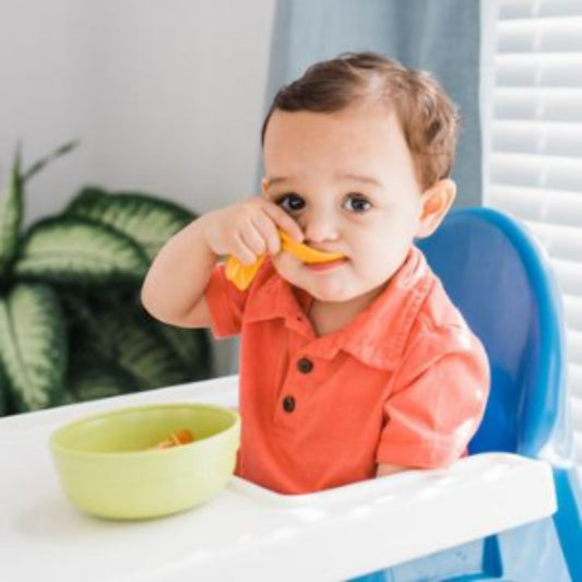 Cuchara ergonómica para bebé diestro en color naranja. Diseño curvo para facilitar la autoalimentación.