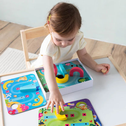 Juego de destreza Funny Ball de Goula para niños desde 3 años. Incluye 4 placas con circuitos y piezas de madera para guiar una bolita, ideal para desarrollar coordinación y pensamiento lógico.