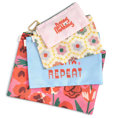 Set de Estuches Las Flores: 4 bolsas de nylon con cierres seguros, clip y diseño floral, perfectas para organizar tu equipaje y pertenencias.