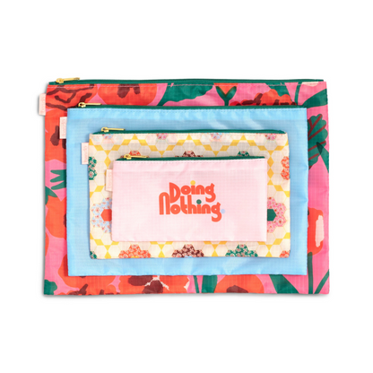 Set de Estuches Las Flores: 4 bolsas de nylon con cierres seguros, clip y diseño floral, perfectas para organizar tu equipaje y pertenencias.