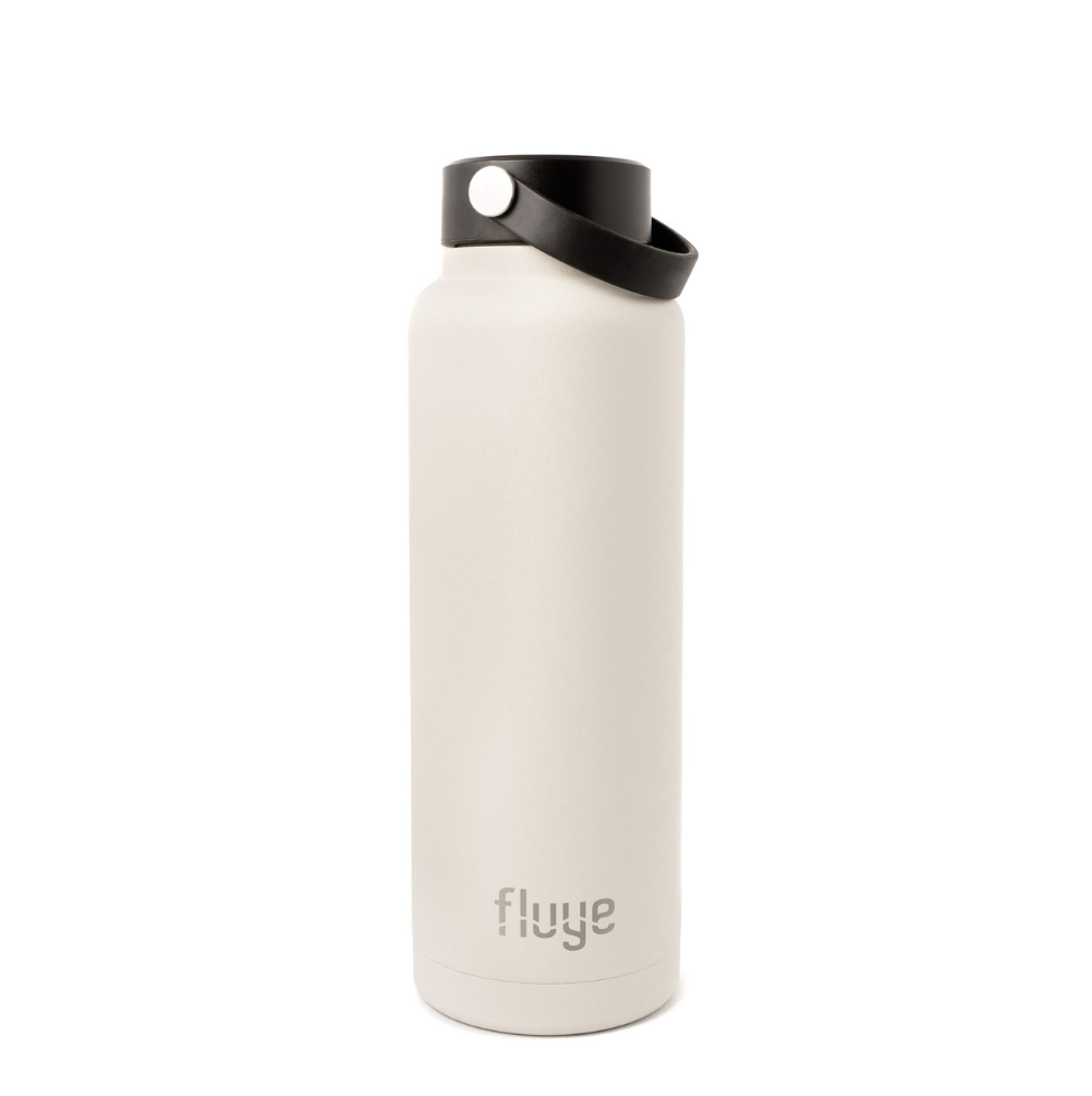 Botella Térmica Fluye Sport 1200ml en color Baja Sand (Beige), fabricada en acero inoxidable de alta calidad, con tapa antiderrame, ideal para mantener bebidas frías por 24h y calientes por 12h.